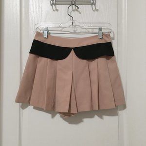Nude pleated skorts with black accents